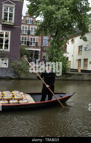 Un fromage fermier dans la ville néerlandaise d'Alkmaar transportant ses fromages sur un petit bateau dans les canaux Banque D'Images