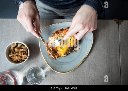 Manger dehors dans un restaurant, l'homme de manger des lasagnes, l'homme ayant lunsh Banque D'Images