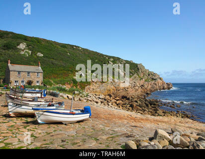 Chalet typique de Cornouailles construit sur le quai à Penberth Cove sur la péninsule de Penwith à l'ouest de Cornwall, Angleterre, Royaume-Uni avec des bateaux de pêche en premier plan. Banque D'Images