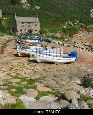 Chalet typique de Cornouailles construit sur le quai à Penberth Cove sur la péninsule de Penwith à l'ouest de Cornwall, Angleterre, Royaume-Uni avec des bateaux de pêche en premier plan. Banque D'Images