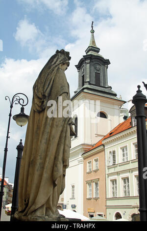 Une statue à l'extérieur de l'église du Saint Esprit à Varsovie, Pologne. Dans l'arrière-plan est l'église de Saint Hyacinthe. Rue Freta, Vieille Ville. Banque D'Images