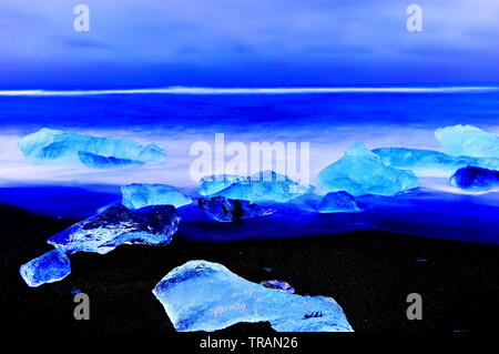 Vue sur les icebergs de la Lagune glaciaire du Jökulsárlón à côté plage à l'Islande, au crépuscule en hiver. Banque D'Images