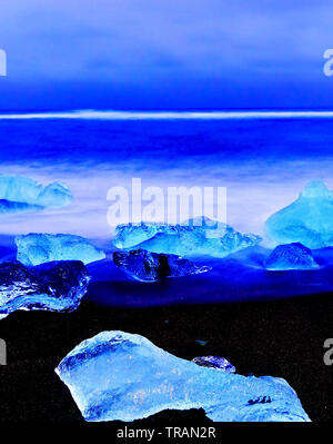 Vue sur les icebergs de la Lagune glaciaire du Jökulsárlón à côté plage à l'Islande, au crépuscule en hiver. Banque D'Images