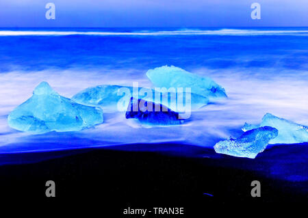 Vue sur les icebergs de la Lagune glaciaire du Jökulsárlón à côté plage à l'Islande, au crépuscule en hiver. Banque D'Images