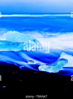 Vue sur les icebergs de la Lagune glaciaire du Jökulsárlón à côté plage à l'Islande, au crépuscule en hiver. Banque D'Images