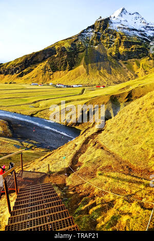 Vue sur le sentier de randonnée à côté de Skogafoss chute d'eau gelée en Islande. Banque D'Images