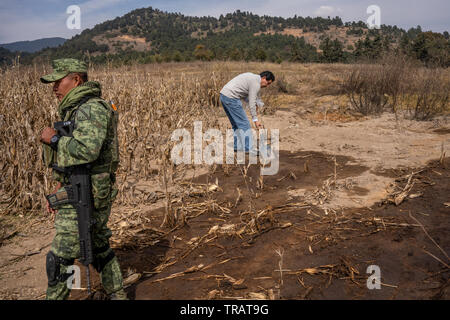 Armando Tapia, de l'Benemrita Universidad Autonoma de Puebla, prélève des échantillons de sol contaminé, à gauche plus de gaz illégal le vol, près de la communauté La Preciosita, Puebla, Mexique, le 16 janvier 2019. L'état de Puebla est connu pour ses hautes quantités de gaz illégales de vol. Banque D'Images