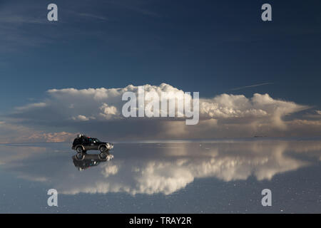 Les voitures qui circulent à travers le Salar de Uyuni en journée Banque D'Images