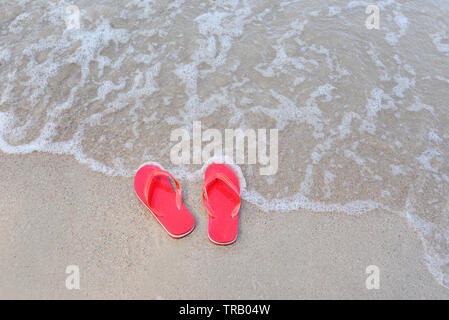 Tongs sur la plage avec des vagues à la plage de sable de mer océan - Vue de dessus Banque D'Images