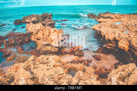 Les vagues de la mer frappé des rochers sur la plage de Coqueirinho,Paraiba, Brésil. Des pierres propres on Beach Banque D'Images