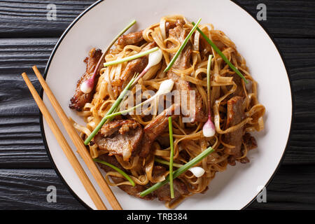 Chow Fun boeuf - Boeuf sauté aux nouilles de riz, germes de haricots, oignons de printemps et la ciboulette chinoise est un célèbre plat cantonais libre sur la plaque sur th Banque D'Images