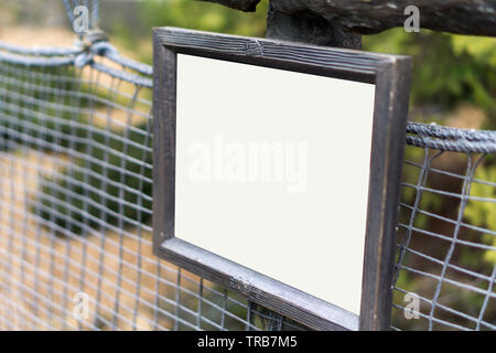 Blanc vide en bois panneau d'avertissement sur mur fil Banque D'Images