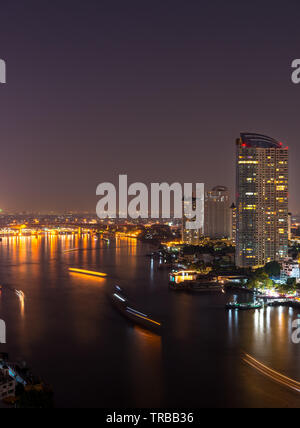 La Chao Phraya à Bangkok, la nuit. Windows dans les maisons illuminées le long de la rivière. Banque D'Images