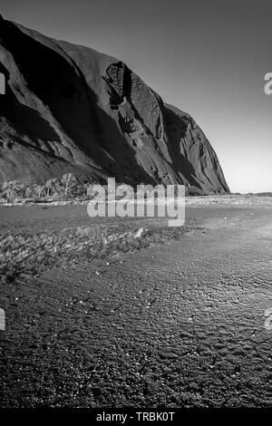 Le soleil brille sur le sentier menant à la base du grand monolithe Uluru (Ayers Rock) au coeur de l'Australie, l'Outback. Banque D'Images