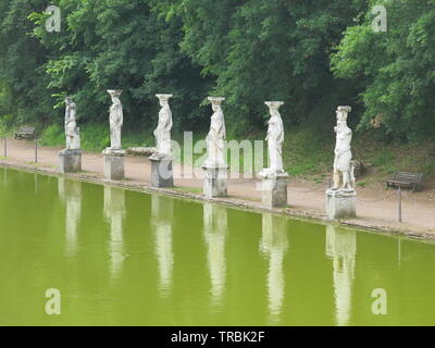 Rangée de statues grecques, reflétée dans l'eau, les lignes de la longueur de la piscine de la Villa Adriana Canopus, Site du patrimoine mondial de l'UNESCO à partir de temps d'Hadrien Banque D'Images