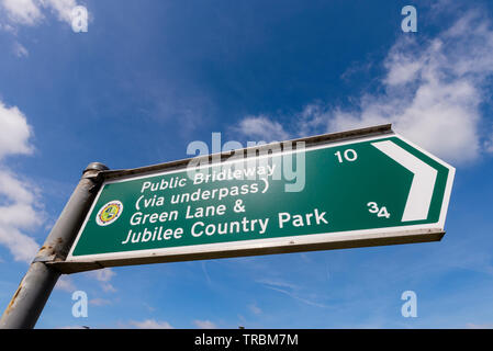 Pont public vers Green Lane & Park panneau de direction. Panneau vert avec informations sur la destination et la distance. Dehors par jour ensoleillé Banque D'Images