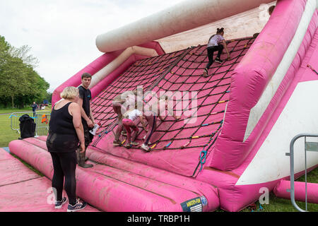 Warrington, Royaume-Uni. 2 juin 2019. Race for Life 2019, Warrington, au profit de la recherche sur le cancer. Les enfants à l'aide d'un filet à grimper une diapositive gonflable Banque D'Images