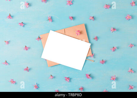 Carte de vœux en blanc avec des fleurs de cerisier au printemps bleu sur fond de bois. Télévision. vue d'en haut.. La maquette concept de printemps. mariage ou fête des mères backgrou Banque D'Images