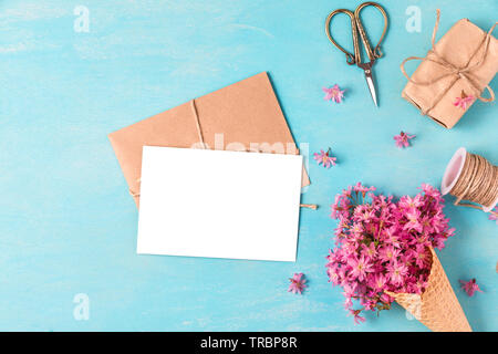 Carte de vœux en blanc et de la crème glacée de cherry blossom rose fleurs en cornet gaufré de couleur pastel sur fond bleu avec bourgeons. Télévision. vue d'en haut. weddi Banque D'Images