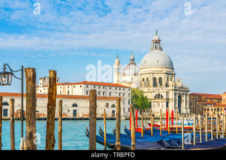 Belle vue sur le Grand Canal avec Basilique historique di Santa Maria della Salute en arrière-plan et gondoles sur une journée ensoleillée à Venise, Italie Banque D'Images