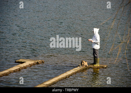 Un homme qui pêche dans le lac Kawaguchiko près du Mont Fuji, au Japon Banque D'Images