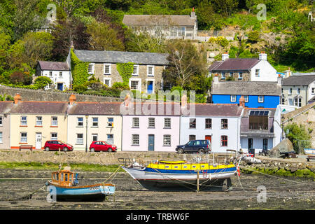 Chalets et bateaux. Fishguard Harbour à marée basse, le Parc National de Pembrokeshire Coast, West Wales Banque D'Images