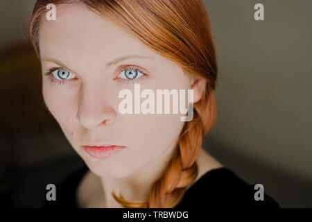 Visage d'une jeune fille qui a des cheveux rouge un grands yeux bleus. Femme polonaise. Banque D'Images