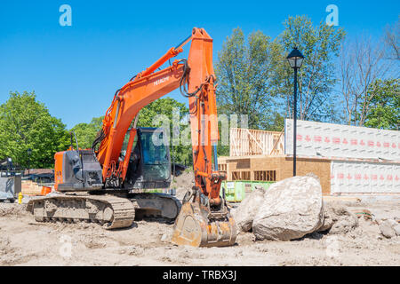 Siège de l'excavateur en face d'une nouvelle maison en construction dans un lotissement. Banque D'Images