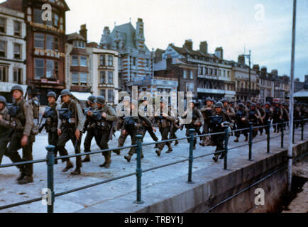 Ces troupes américaines marchons à travers les rues d'une ville portuaire britannique en route pour les docks où ils seront déposés dans des engins de débarquement pour le grand assaut. Juin, 1944 Banque D'Images