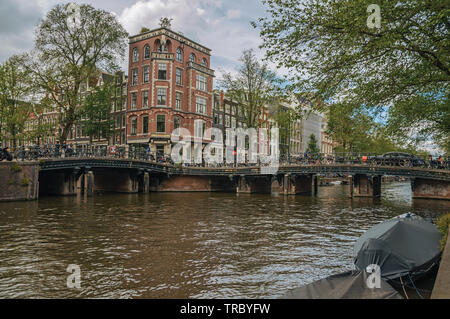 Avec des vélos sur le pont canal, les bâtiments en briques anciennes et de nuages pendant la journée à Amsterdam. L'activité culturelle de la ville avec d'énormes, les canaux et les ponts en Pays-Bas. Banque D'Images