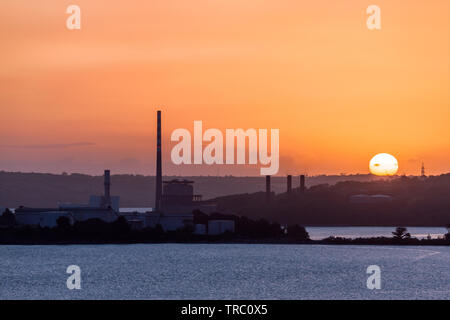 Aghada, Cork, Irlande. 06Th Juin, 2019. Sur une maison de banque lundi, le soleil se lève derrière les réservoirs de stockage à la raffinerie de pétrole et de l'ESB à Aghada, co Cork, Irlande. Crédit ; David Creedon / Alamy Live News Banque D'Images