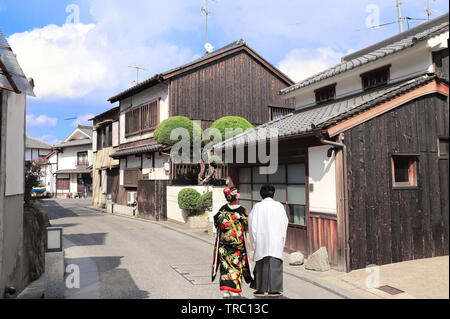 L'homme et la femme dans des vêtements traditionnels japonais kimono et hakama à pied sur la rue médiévale dans quartier Bikan, Kurashiki, Japon Banque D'Images