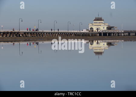 Melbourne, Australie. St Kilda Pier sur une journée calme reflète parfaitement dans les eaux peu profondes. Banque D'Images