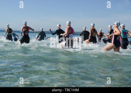 Grand groupe de concurrents dans la course féminine à côté de la plage de surf, triathlon, Calalla Banque D'Images
