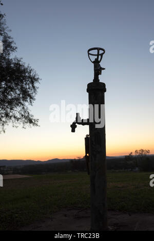 La silhouette d'un bulleur ou fontaine à eau contre le soleil levant sur les retraités Hill Lookout à Gunnedah, nord ouest de la Nouvelle-Galles du Sud, Australie Banque D'Images