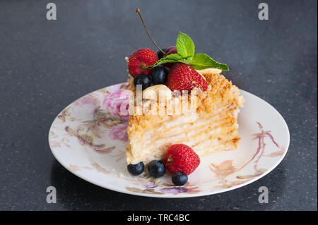 Un morceau de gâteau Napoléon sur la plaque avec les petits fruits Banque D'Images