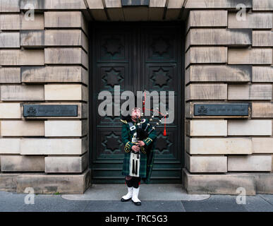 Piper écossais jouer de la cornemuse sur Royal Mile d'Édimbourg à l'extérieur de la Haute Cour de la vieille ville d'Édimbourg, Écosse, Royaume-Uni Banque D'Images