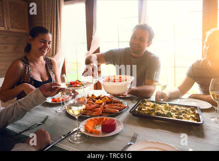 Gros plan du tableau avec le vin blanc, crevettes, salade et graten Banque D'Images