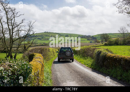 Voiture sur une route de campagne près de le Bourg-d'Oisans dans le Shropshire campagne sur une belle journée de printemps ensoleillée. Banque D'Images