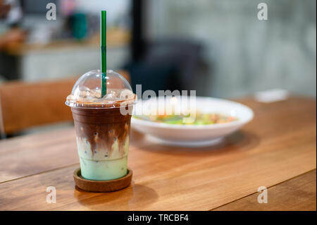 Glace boissons chocolat menthe verte en plastique verre sur table en bois Banque D'Images