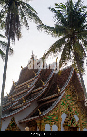 Palmiers flank Haw Pha Bang temple dans le centre de Luang Prabang. L'ancienne capitale royale a la liste du patrimoine mondial pour ses temples bouddhistes. Laos LAO Banque D'Images