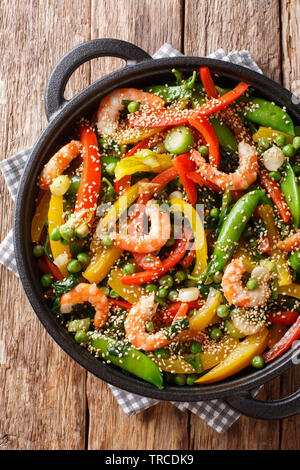 Crevettes sauté aux légumes, close-up de sésame dans une poêle sur la table. Haut Vertical Vue de dessus Banque D'Images