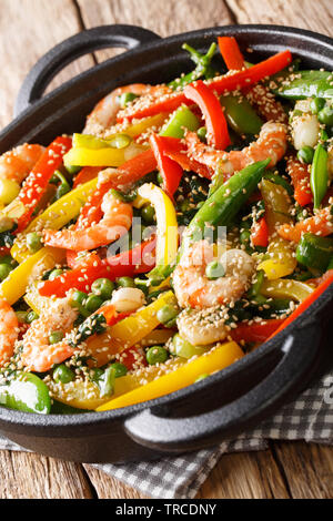 Crevettes sauté aux légumes, close-up de sésame dans une poêle sur la table. vertical Banque D'Images