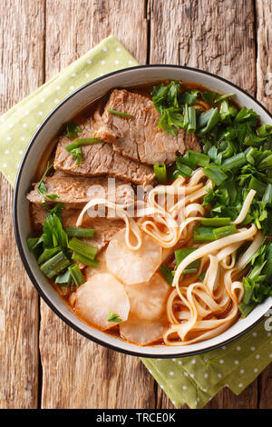 Recette nouilles boeuf Lanzhou le bouillon de boeuf servi avec melt-dans-votre-bouche, tranches de boeuf tendre, radis huile de chili et les nouilles dans un bol gros plan sur le t Banque D'Images