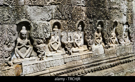 Une rangée de sculptures sculpture sur pierre en ruine dans le mur à l'un des anciens temples de Angkor Thom. (Angkor Wat, Patrimoine Mondial de l'UNESCO, Siem Reap, Cambo Banque D'Images