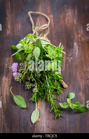 Groupe de différentes herbes pour la cuisine sur fond de bois Banque D'Images