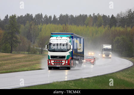 Salo, Finlande. Le 10 mai 2019. Les camions de marchandises le transport de marchandises dans la circulation sur une route de campagne un jour de pluie du printemps dans le sud de la Finlande. Banque D'Images