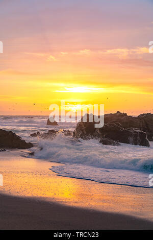 Déménagement des vagues sur le rivage que les couchers de soleil sur l'horizon le long de l'autoroute Un célèbre près de Big Sur, Californie Banque D'Images