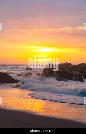 Déménagement des vagues sur le rivage que les couchers de soleil sur l'horizon le long de l'autoroute Un célèbre près de Big Sur, Californie Banque D'Images