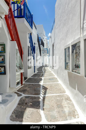 Ruelle étroite dans la ville de Mykonos, avec garde-corps colorés, bordée de grosses pierres et de stuc blanc. Banque D'Images
